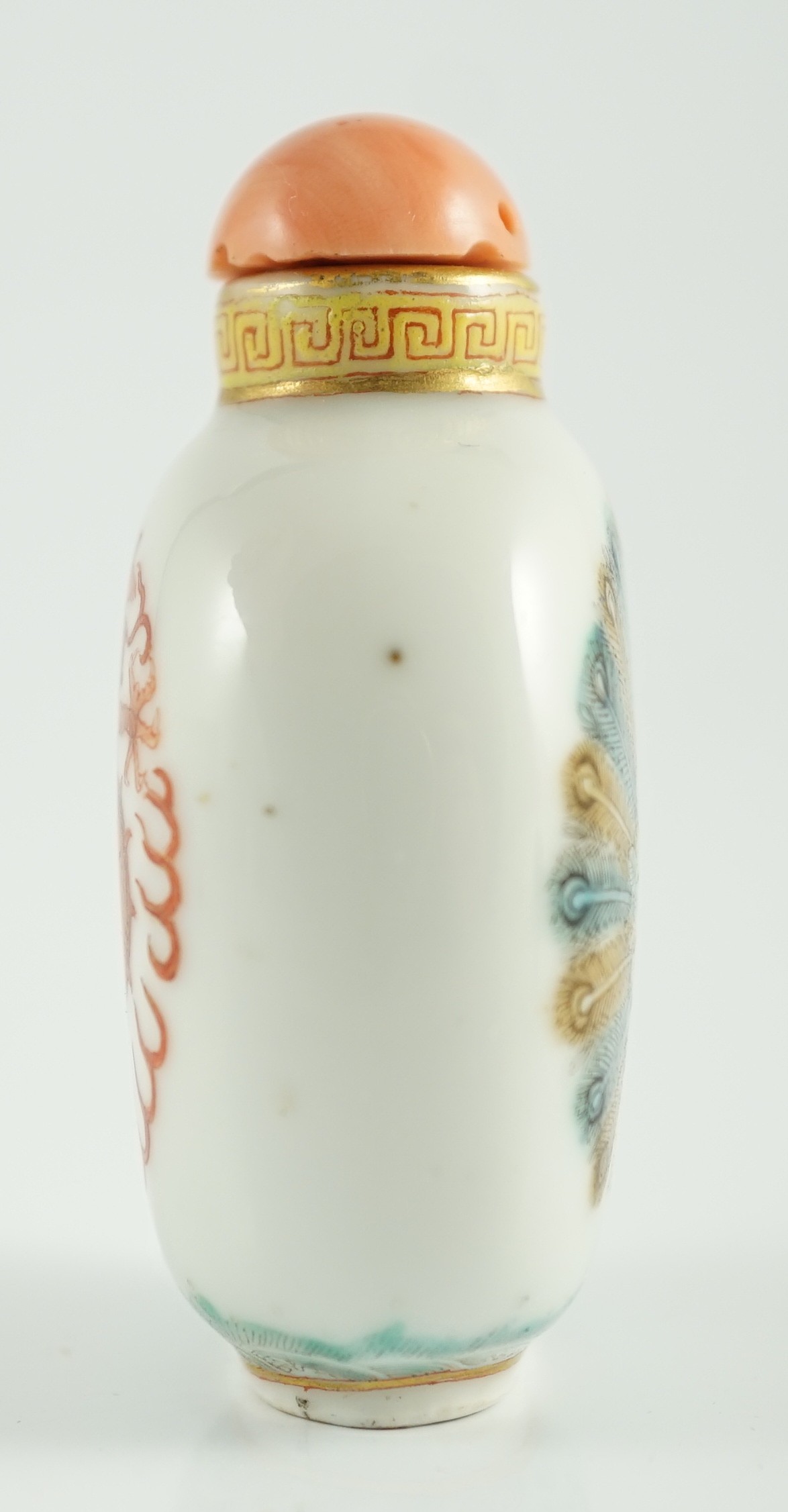 A Chinese enamelled porcelain ‘peacock and dragon’ snuff bottle, Jiaqing mark and period (1796-1820), 5.6cm high, coral stopper and wood stand